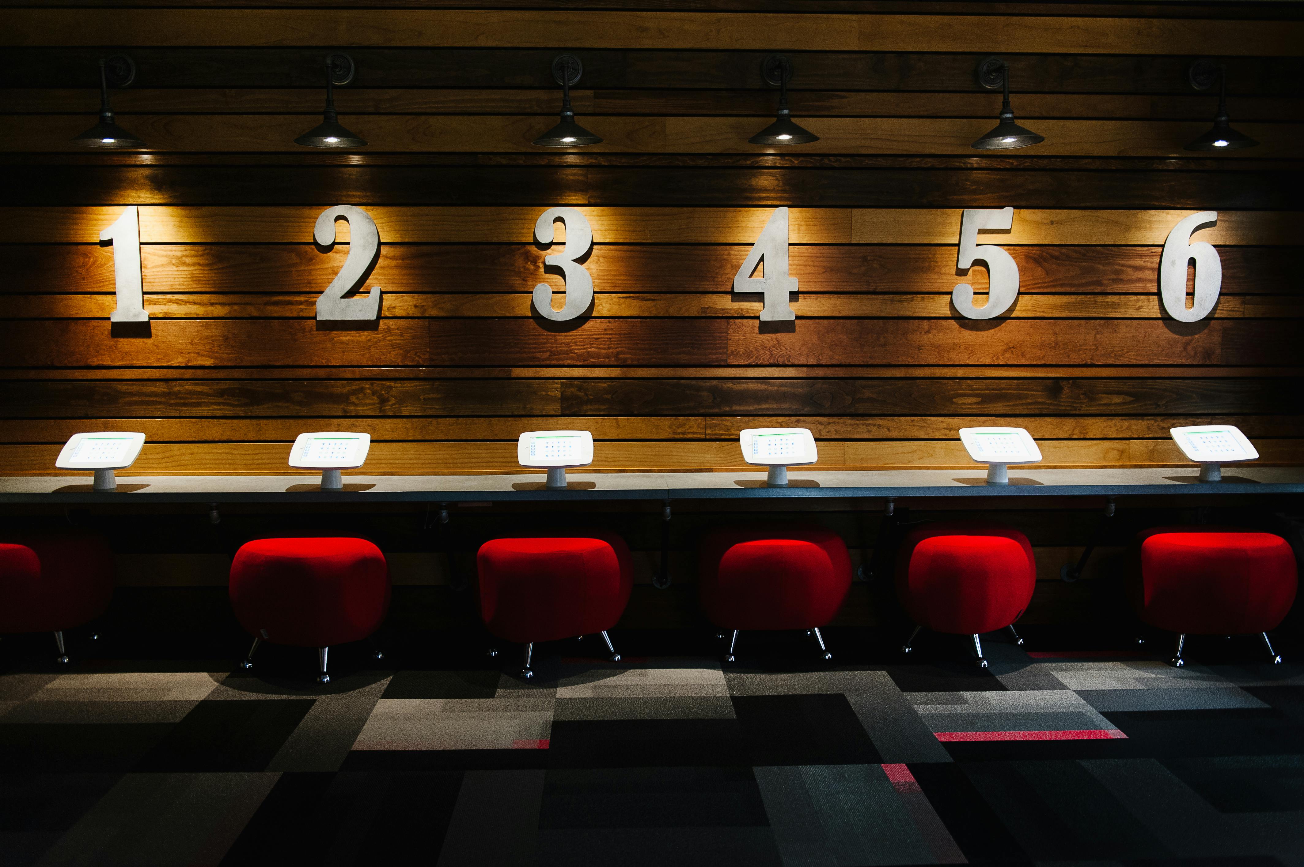 Numbered stations with red stools and tablets