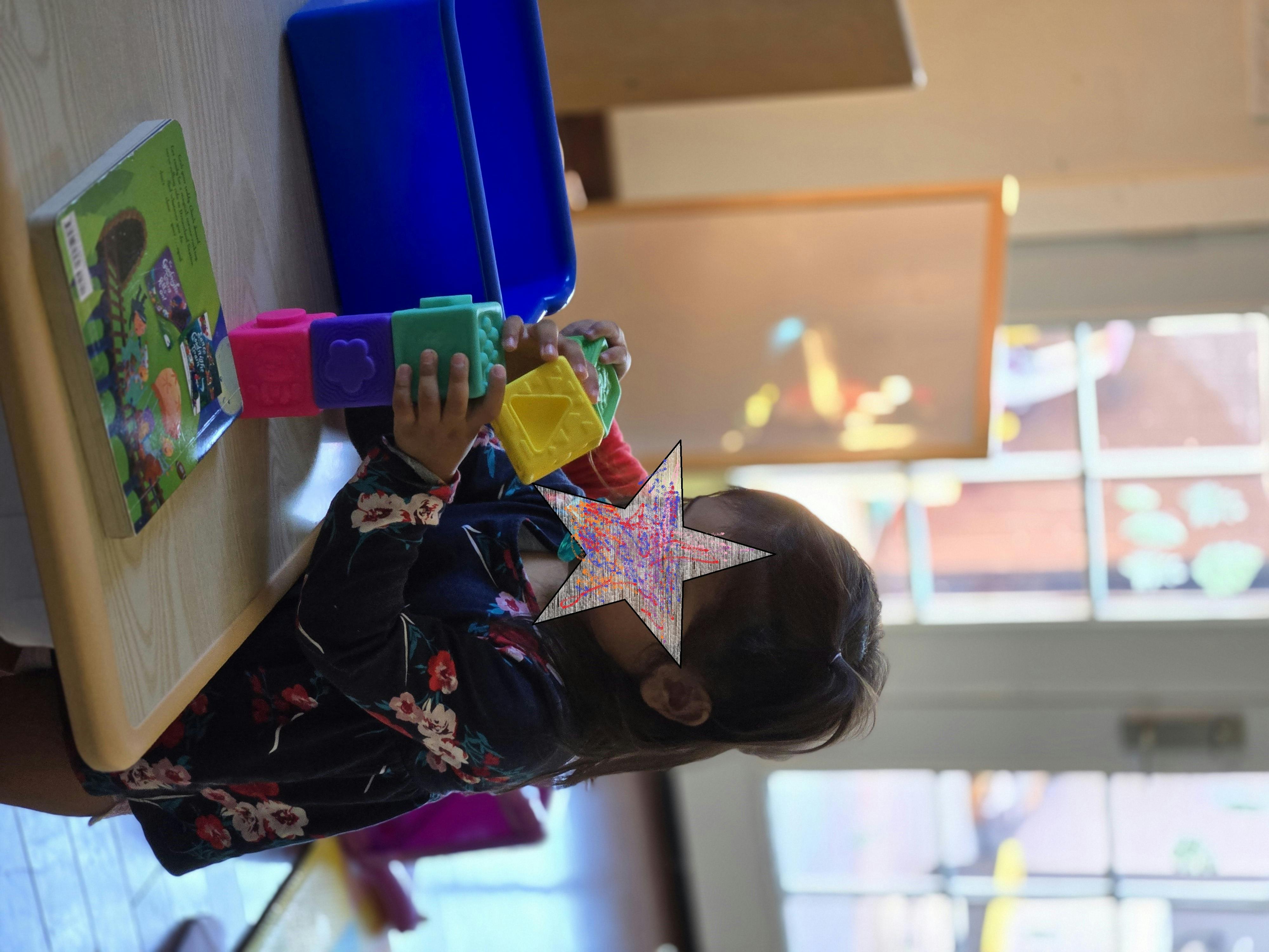 Child playing with colorful block toys on a wooden table