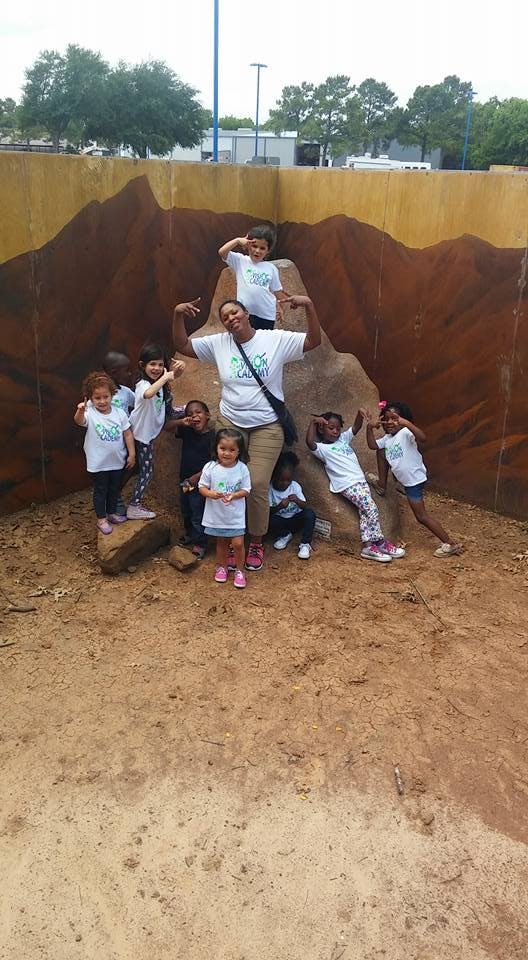 Adult and children posing in front of a painted wall