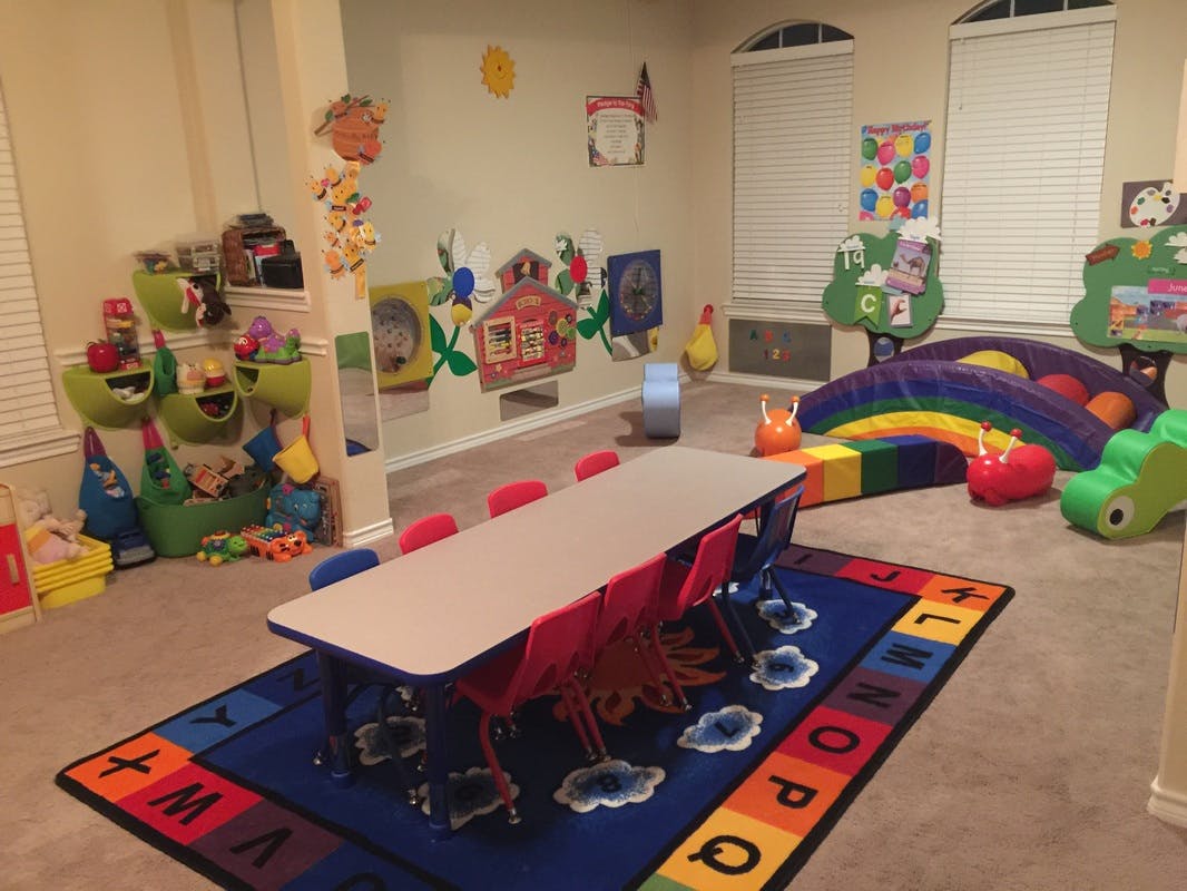 Children's playroom with a long table and chairs, toys, and colorful decor