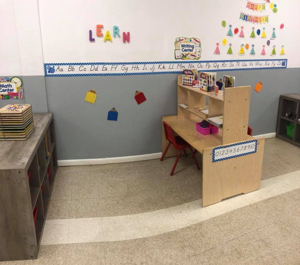 Classroom with a small desk, chair, and storage shelves