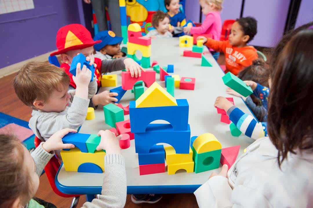 Children playing with colorful building blocks at a table