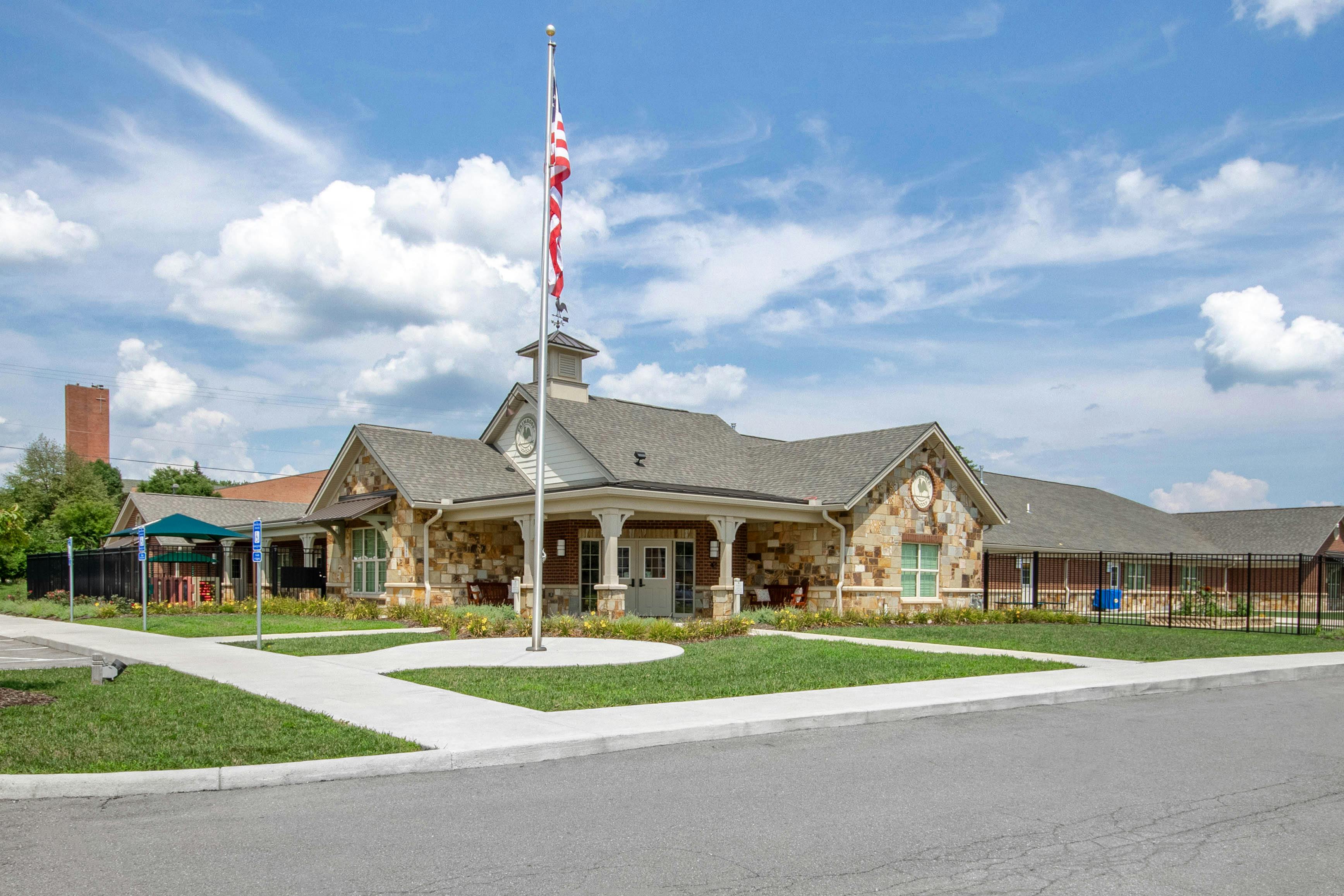 A stone and brick building with a flag pole and American flag in front
