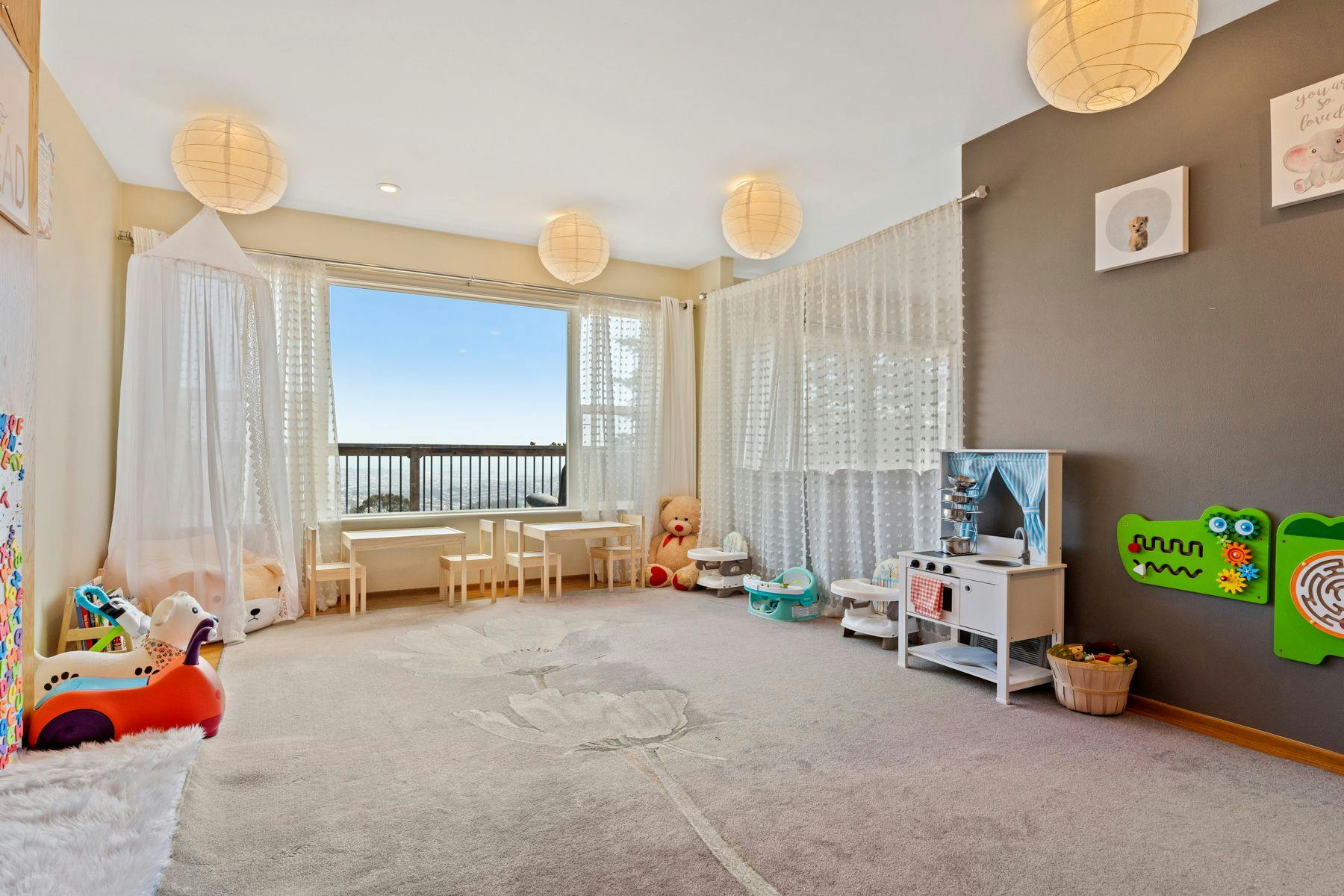 Playroom with toys, small tables and chairs, and a large window
