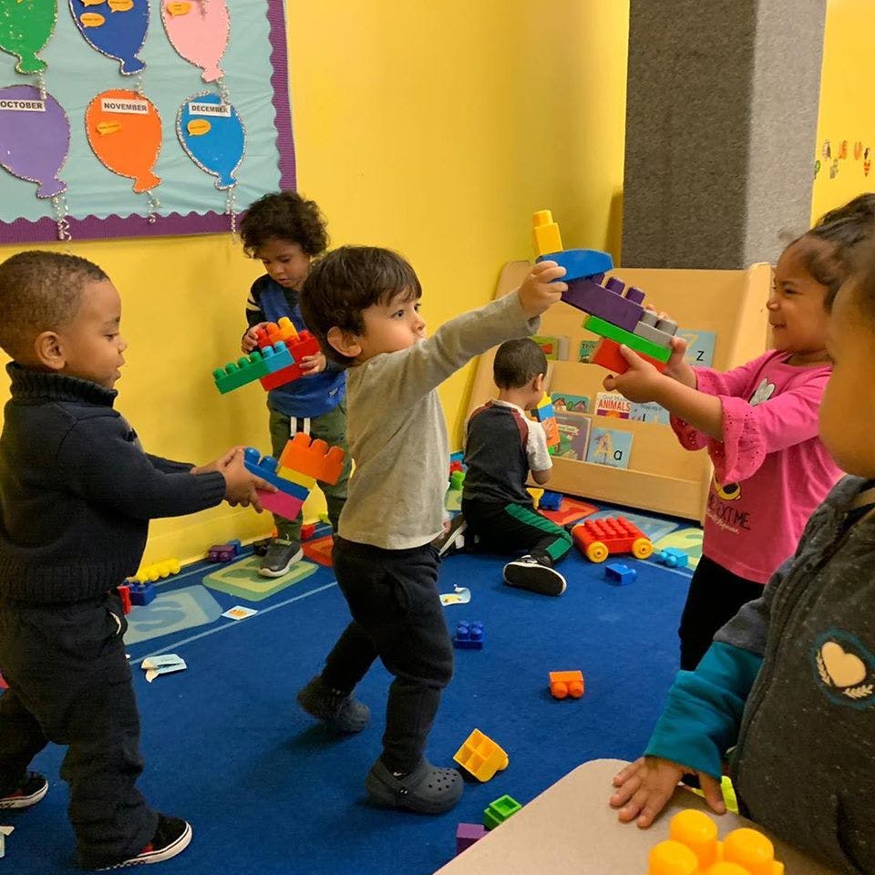 Children playing with colorful building blocks in a classroom