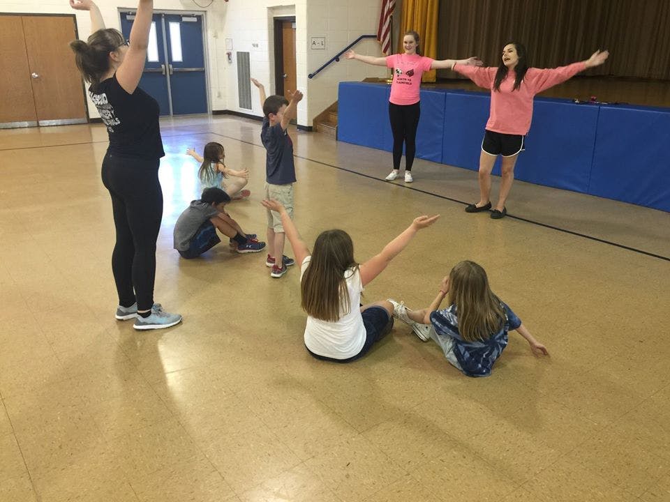 People and children stretching in a gym