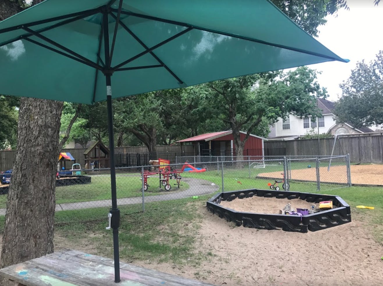 Outdoor playground with sandbox, swings, and play structures