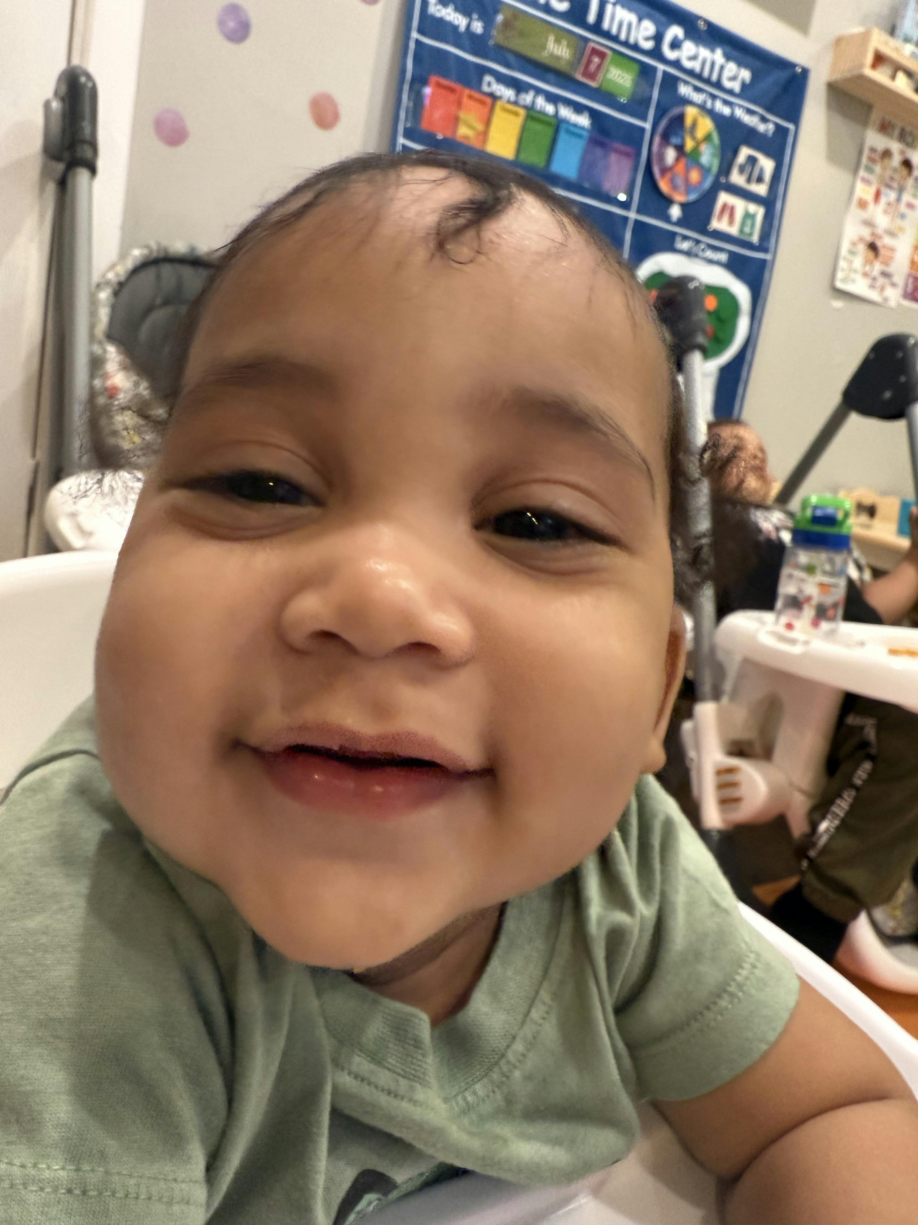 Child in a high chair smiling