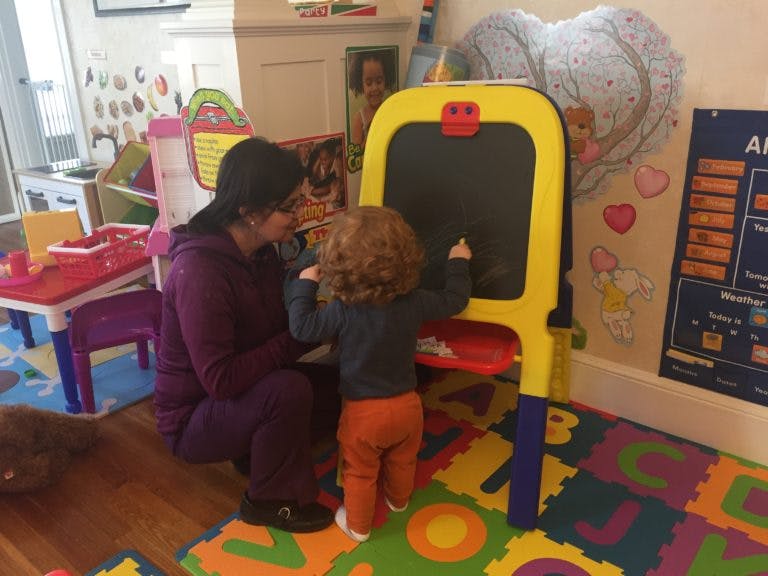 Person and child drawing on an easel