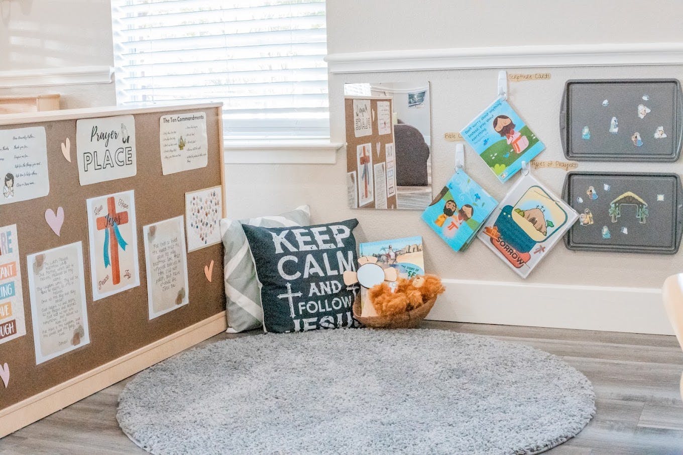 Children's prayer corner with a bulletin board, cushions, and religious decor