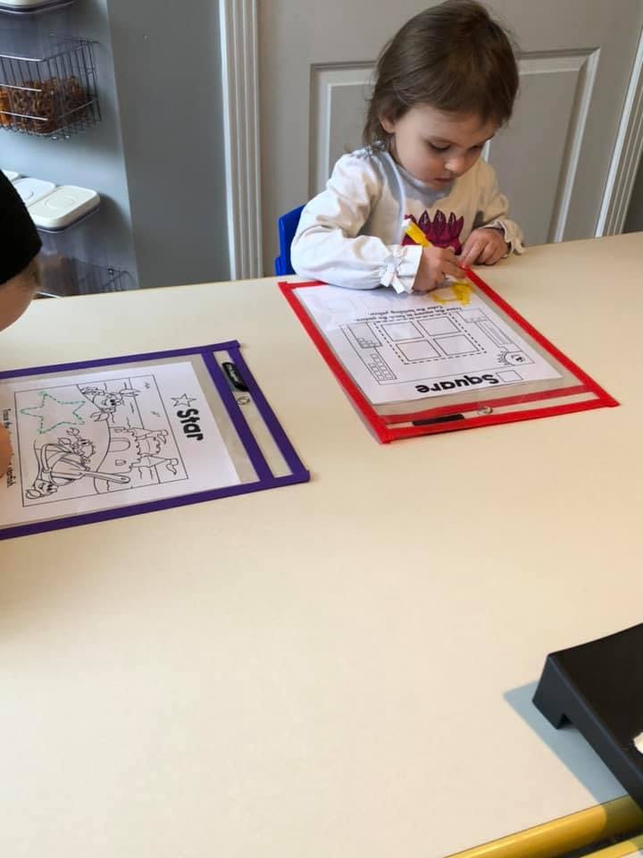 Child drawing on a worksheet at a table