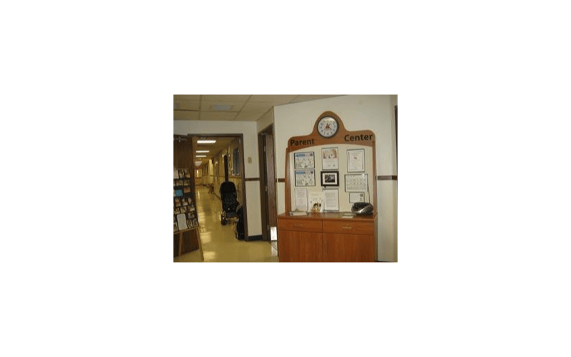 A hallway with a wooden “Parent Center” sign and bulletin board