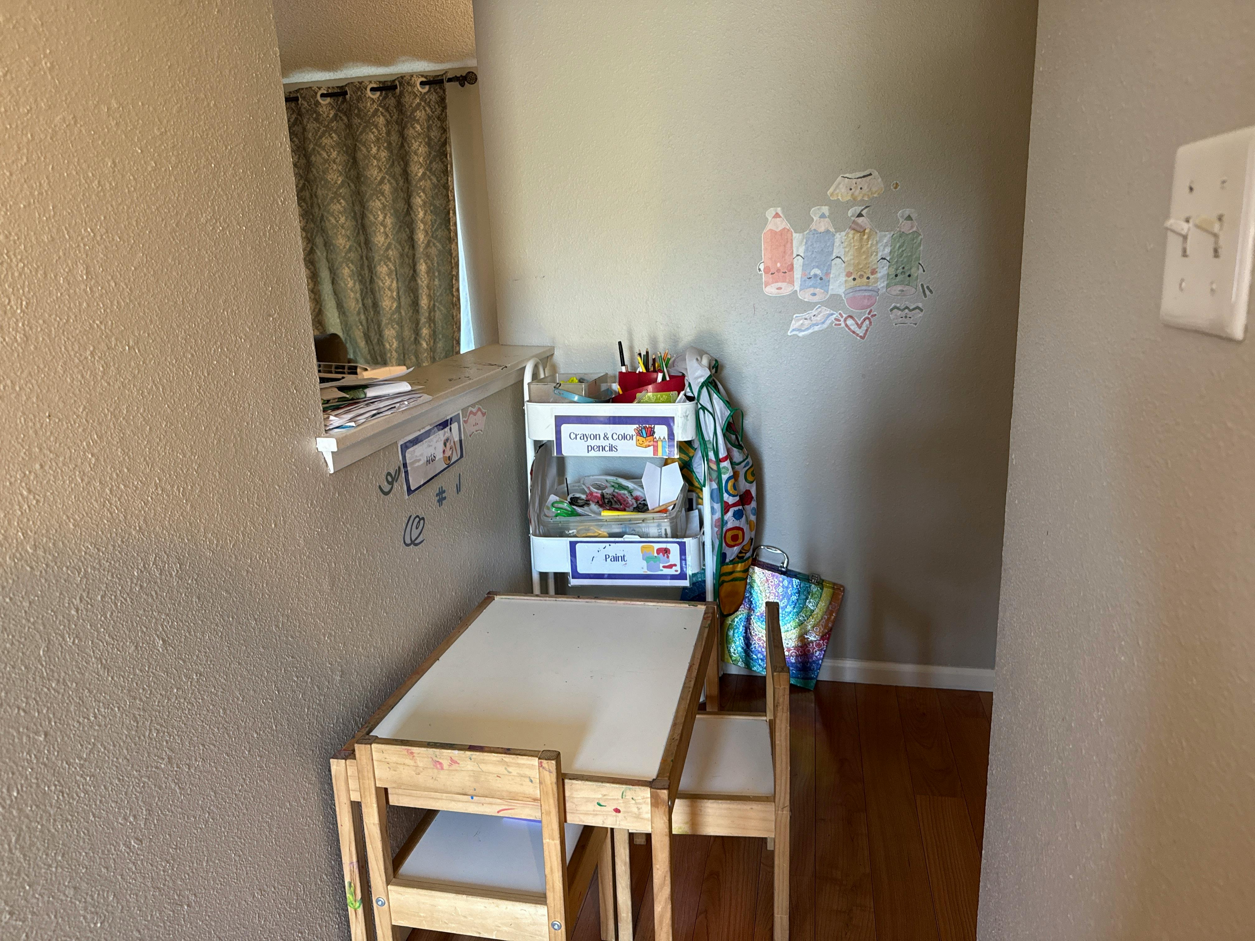 Child's table and chairs with a storage shelf in a room