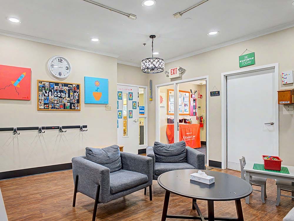 Lounge area with two gray chairs, a coffee table, and an adjacent children's table