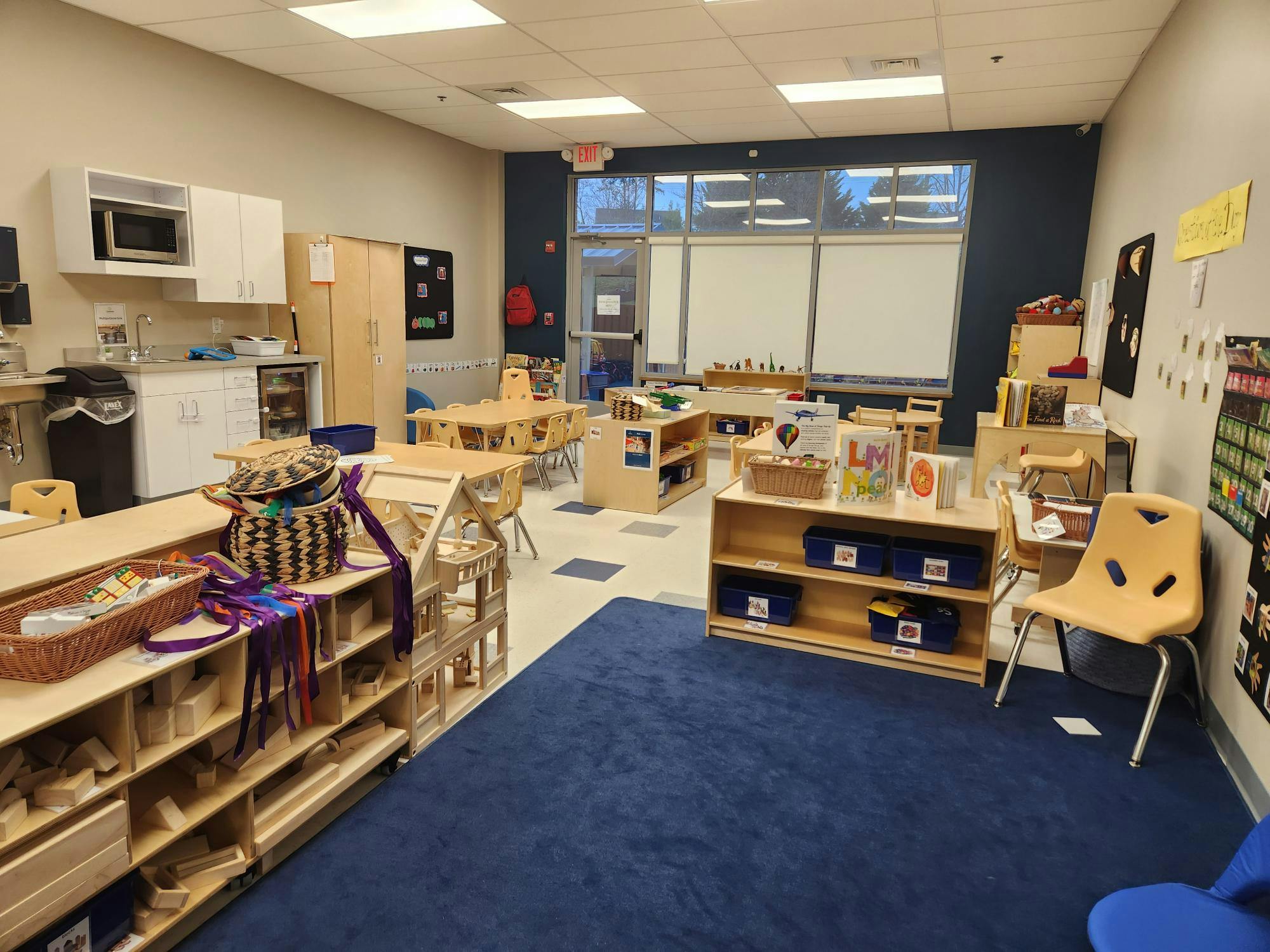 Classroom with tables, chairs, and shelves with learning materials