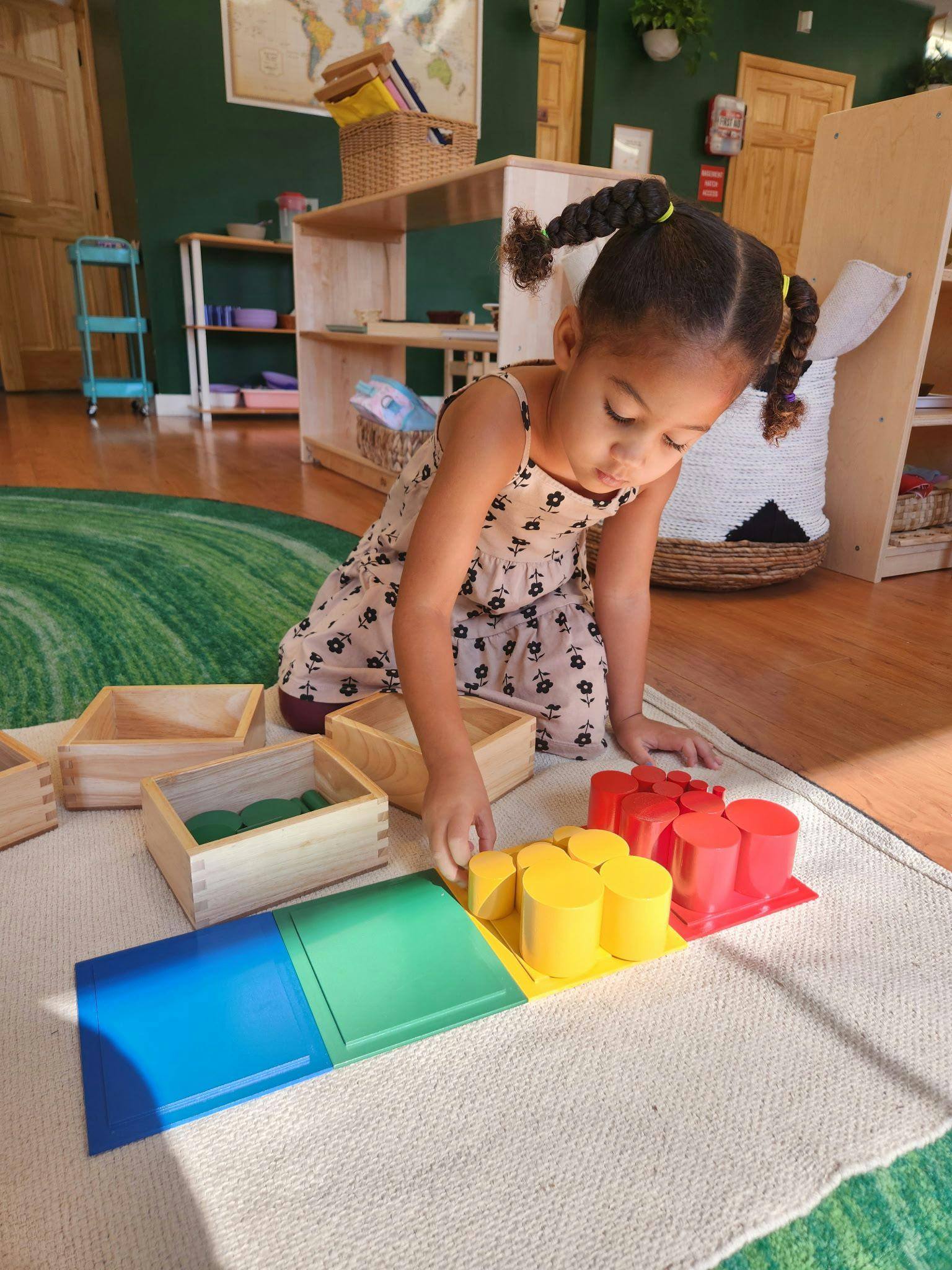 Child playing with colorful cylinder blocks on a rug