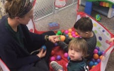Adult and two children playing in a ball pit