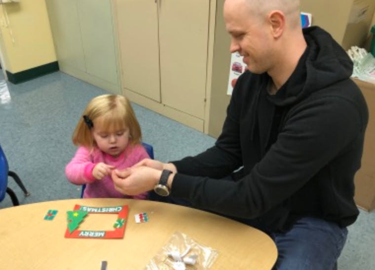 Adult and child at a table doing a craft activity