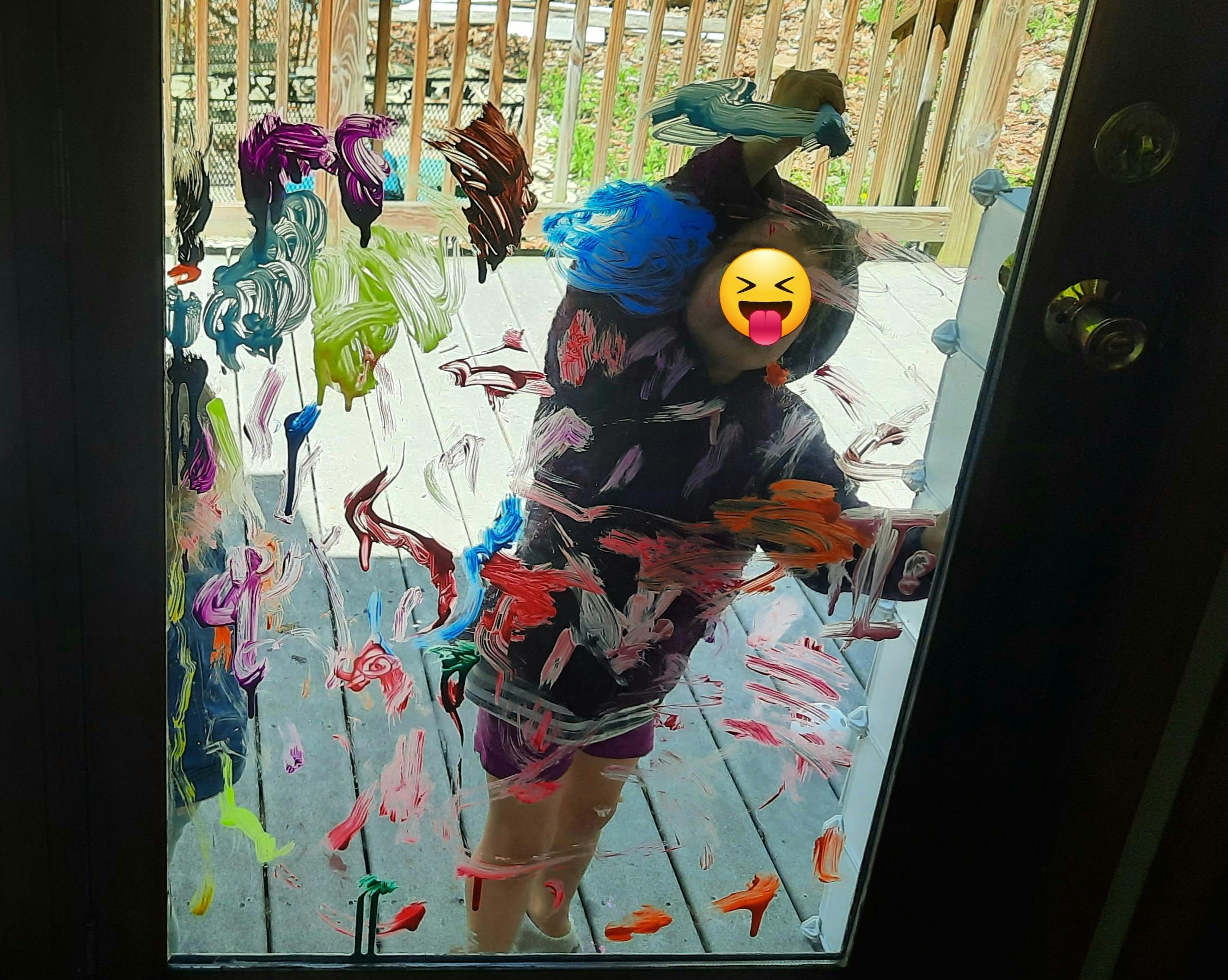 Child painting on a glass door