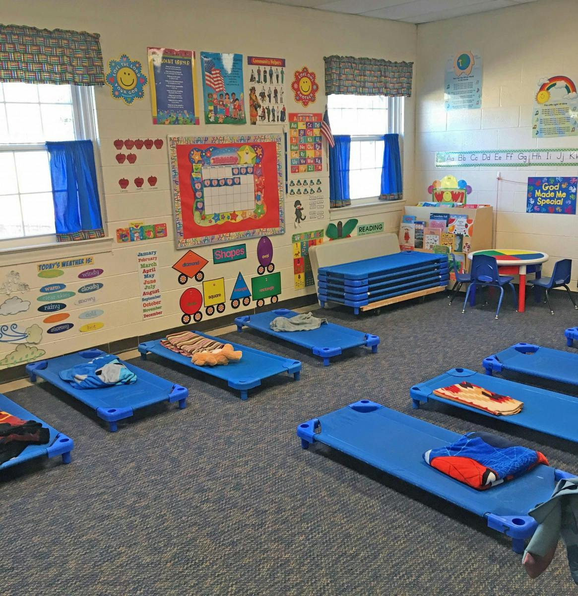 Empty blue cots in a classroom