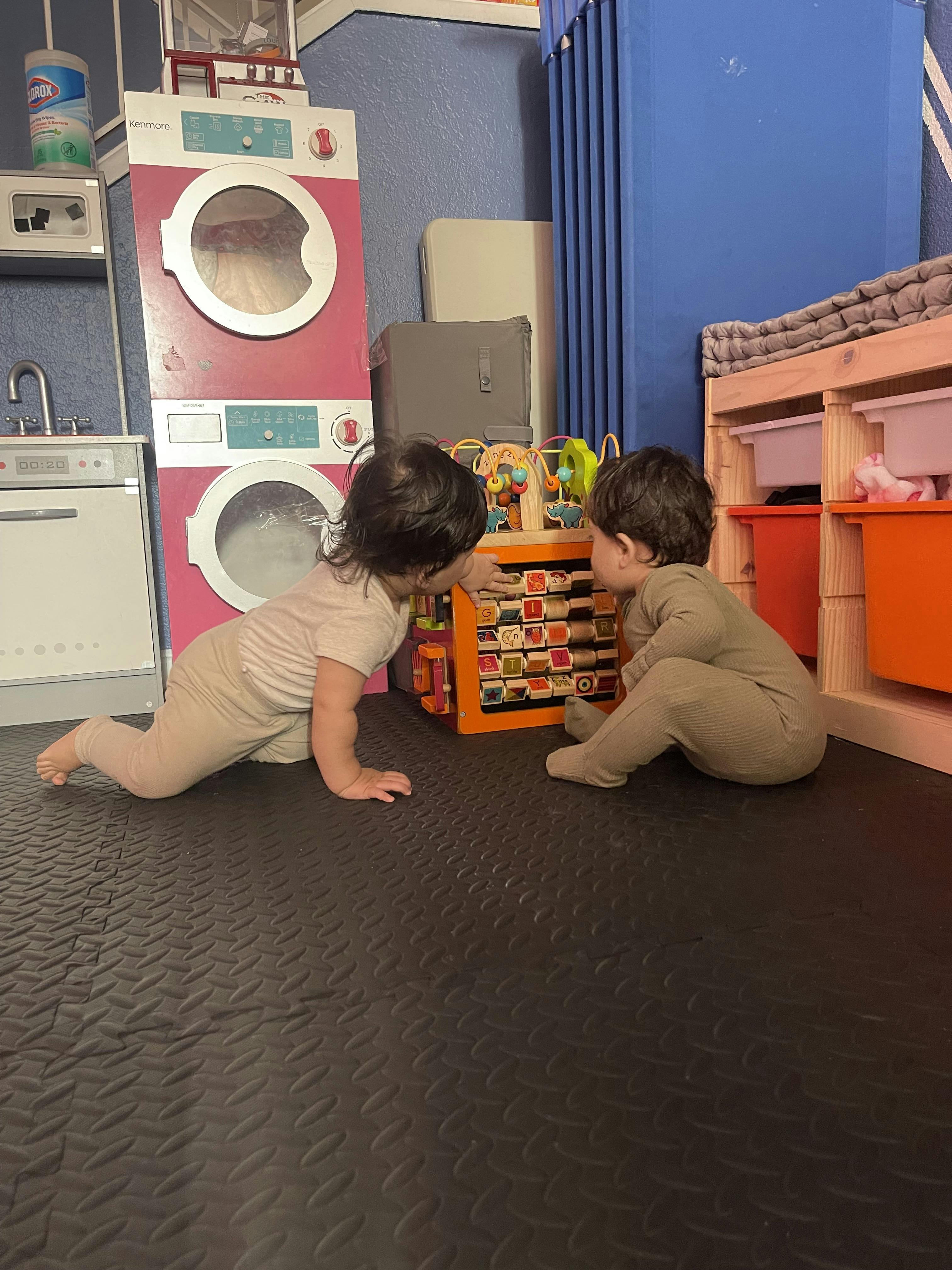 Two children playing with a toy in a play area