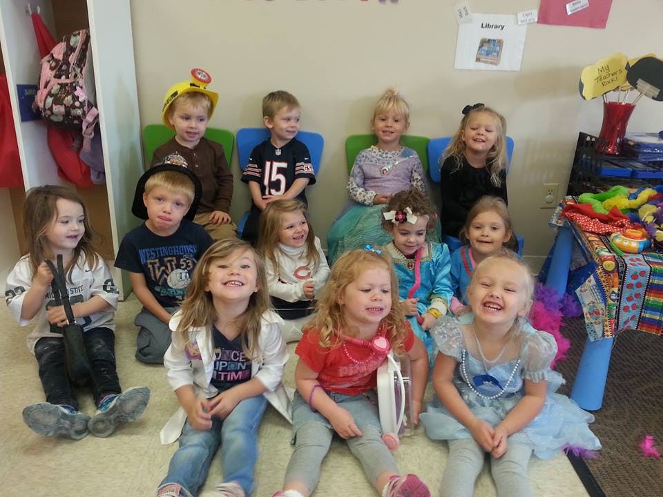 Group of children posing for a photo in a classroom