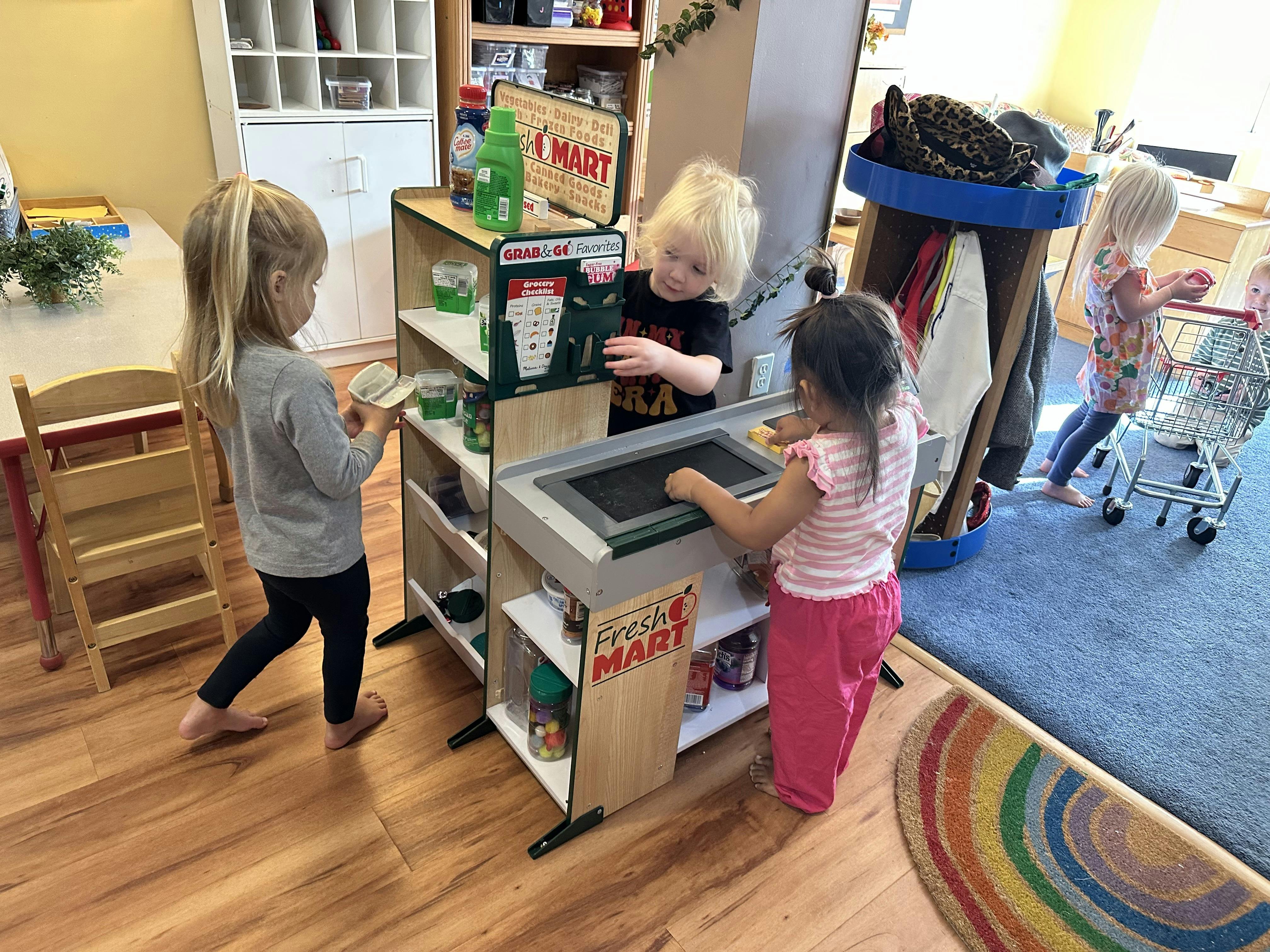 Children playing with a Fresh Mart play grocery store