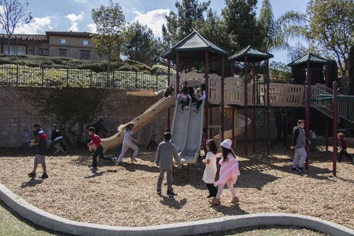 Children playing on a playground structure with slides
