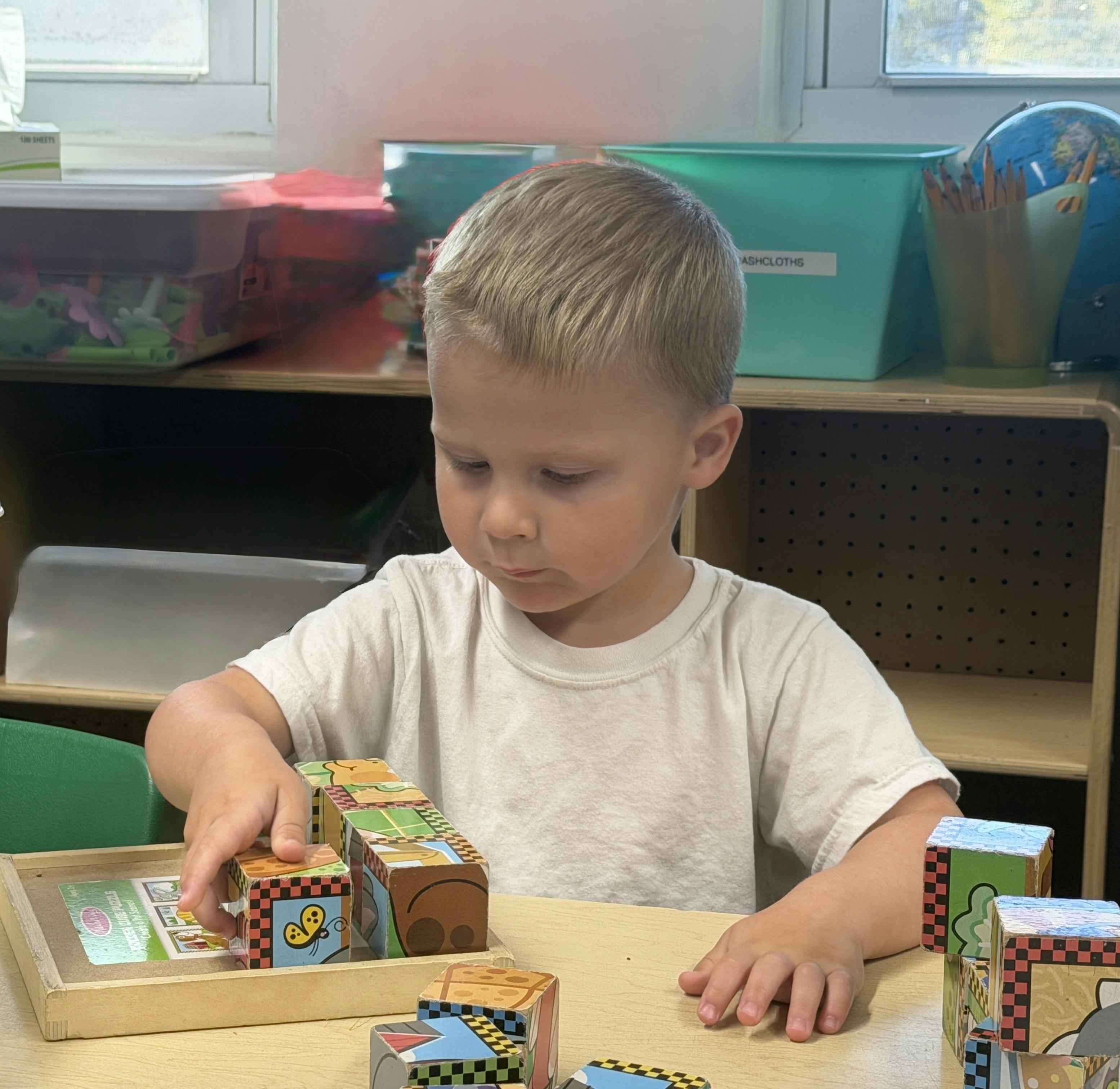Child playing with patterned blocks at a table