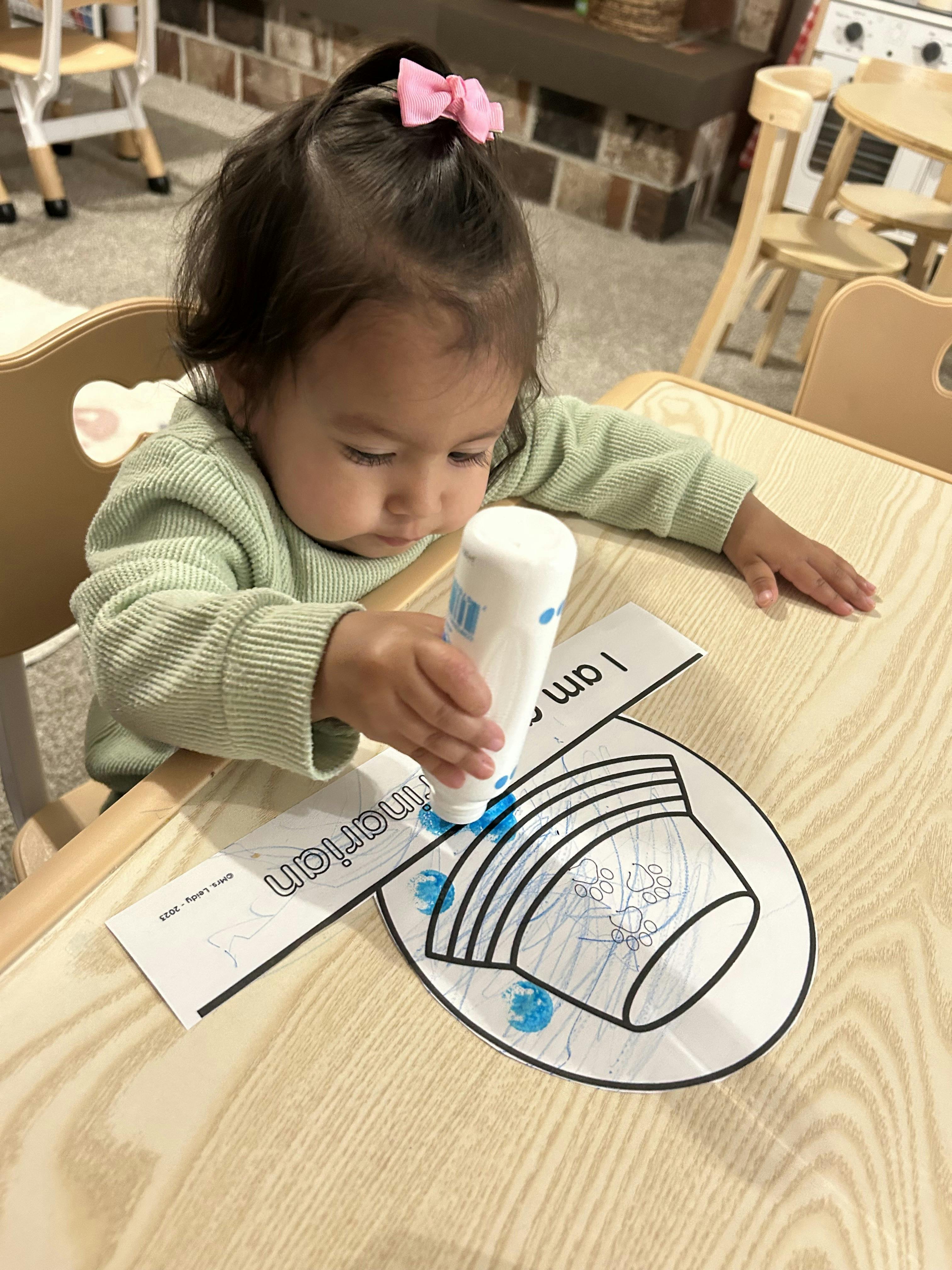 Child using a glue stick on a paper craft