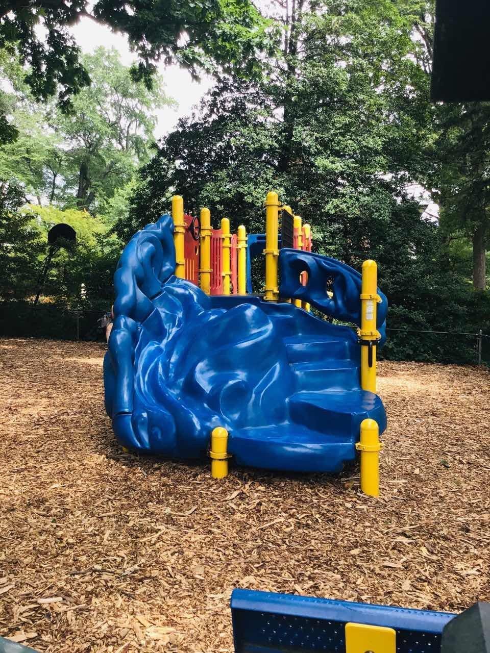 Blue and yellow playground equipment on wood chips