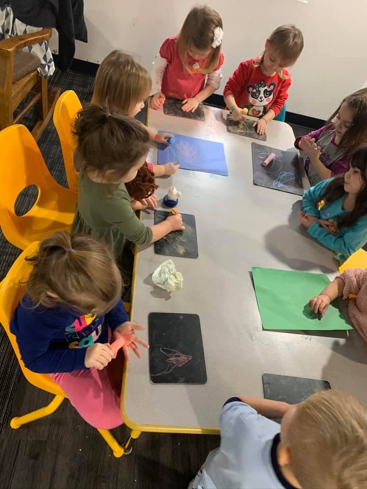 Children sitting around a table doing an art activity