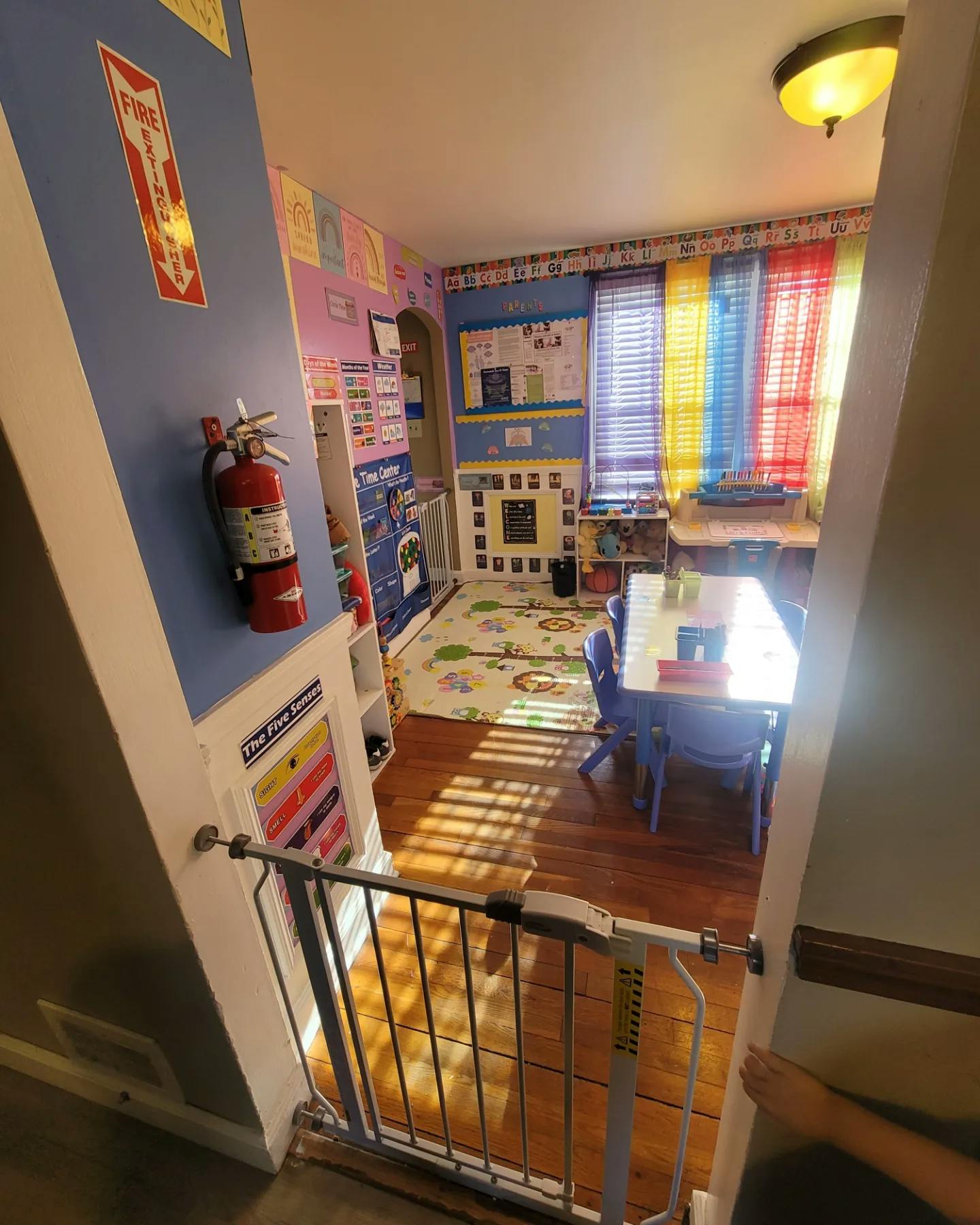 Child safety gate at the top of a staircase leading to a colorful room