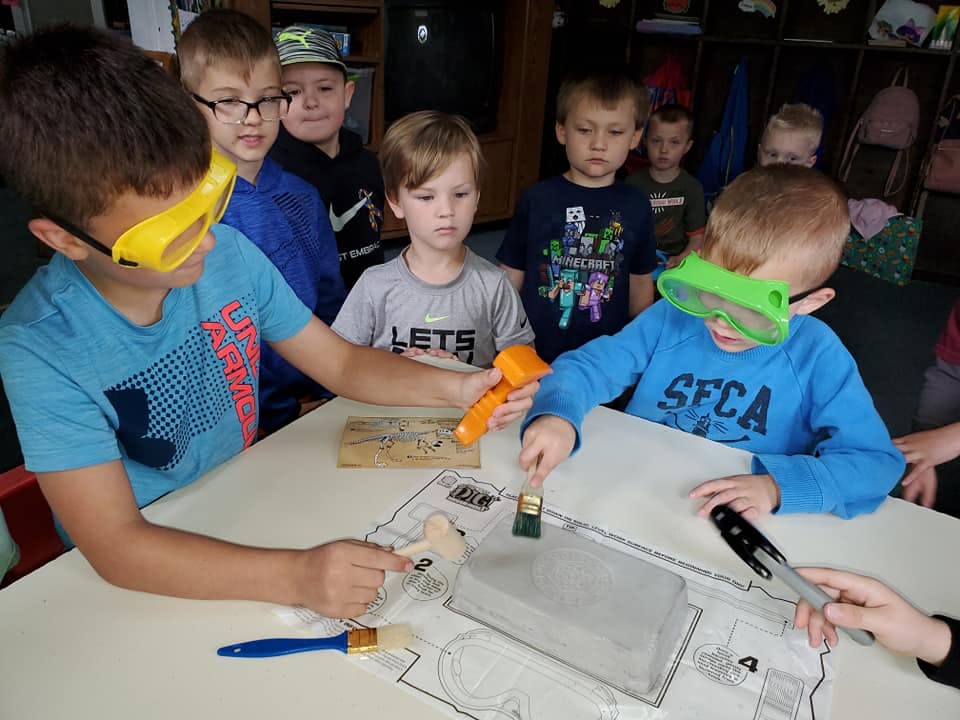 Children wearing safety glasses doing an activity at a table