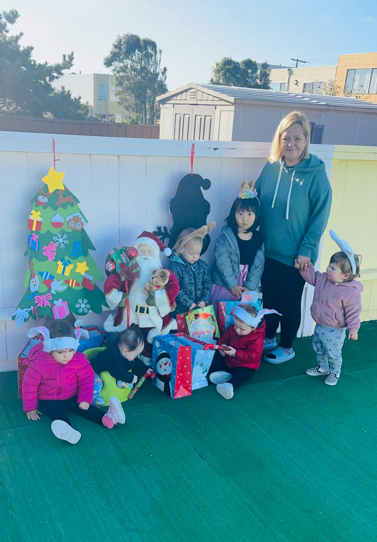 Adult and children with Santa Claus figure and gifts