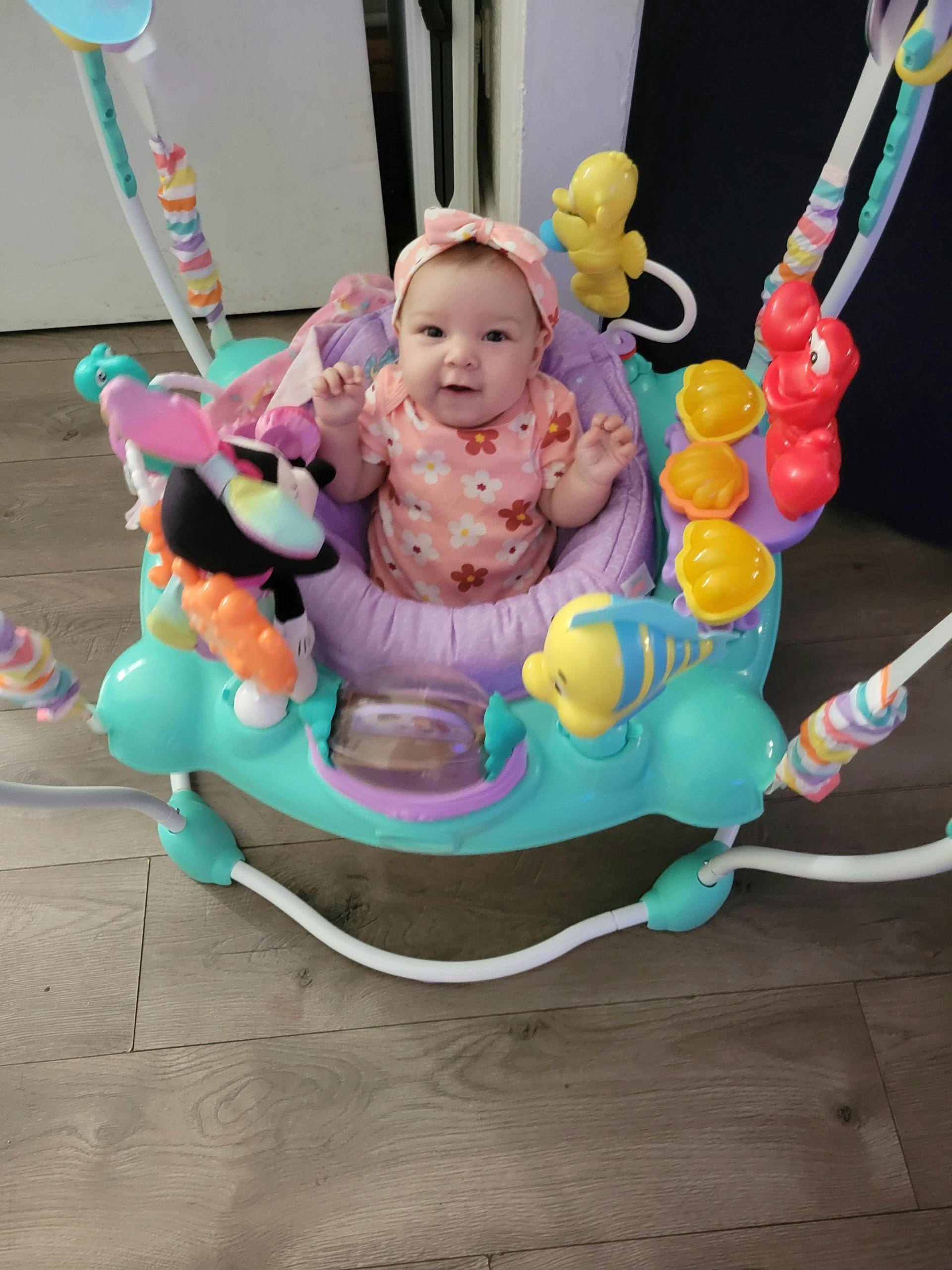 Child in a baby bouncer with toys