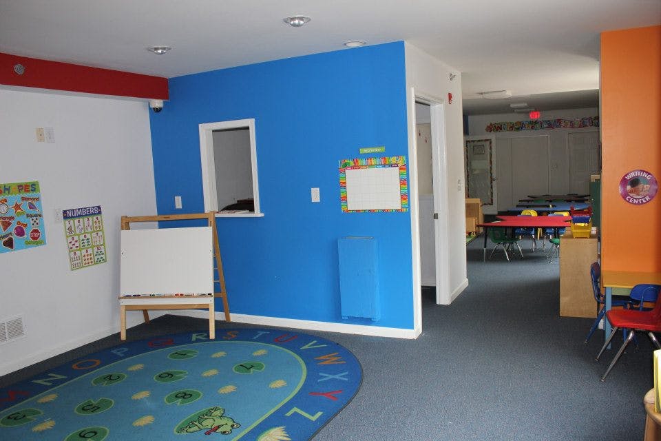 Classroom with blue and white walls, a colorful rug, and a whiteboard