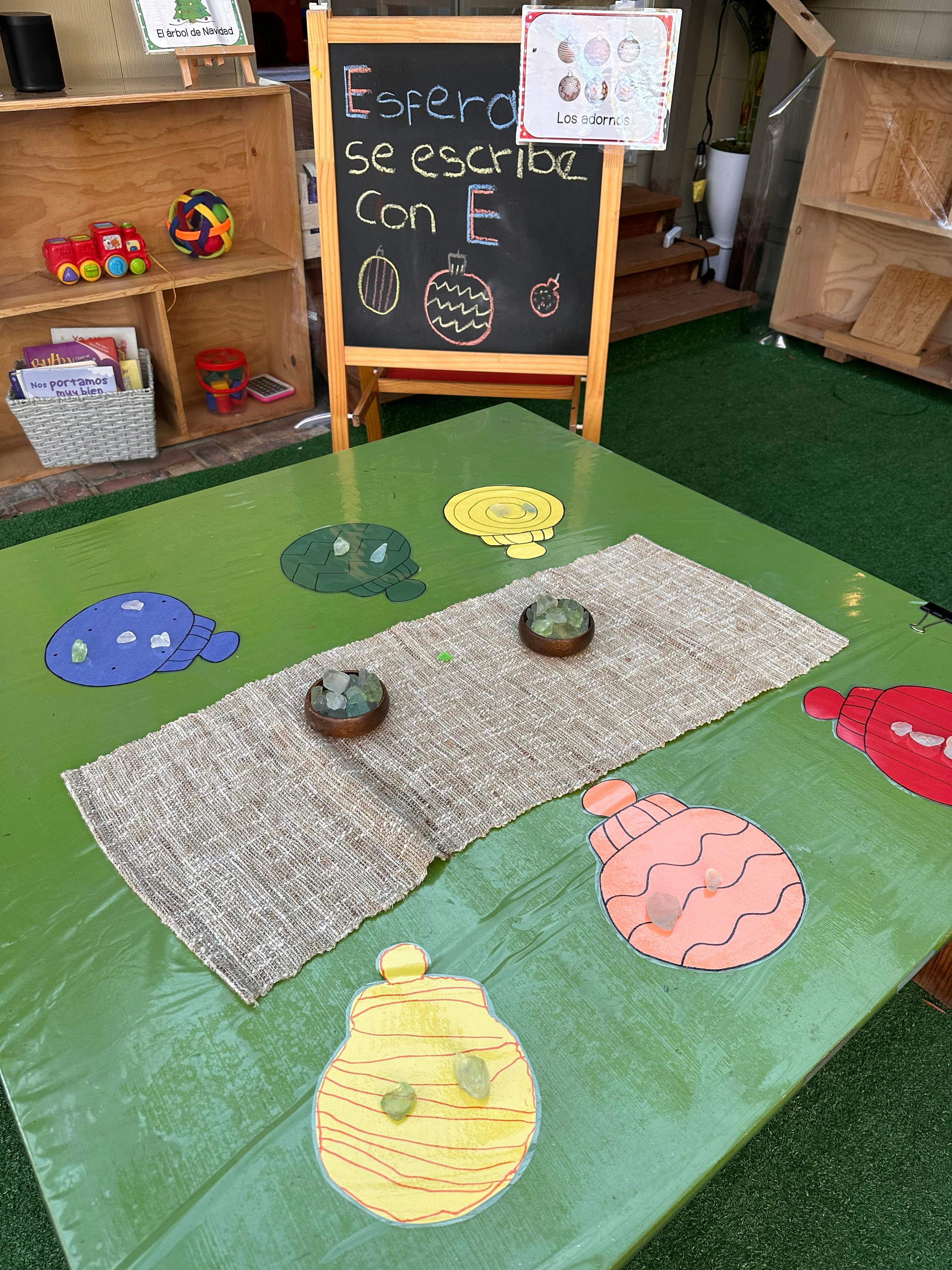 Classroom table with a chalkboard, toys, and craft items