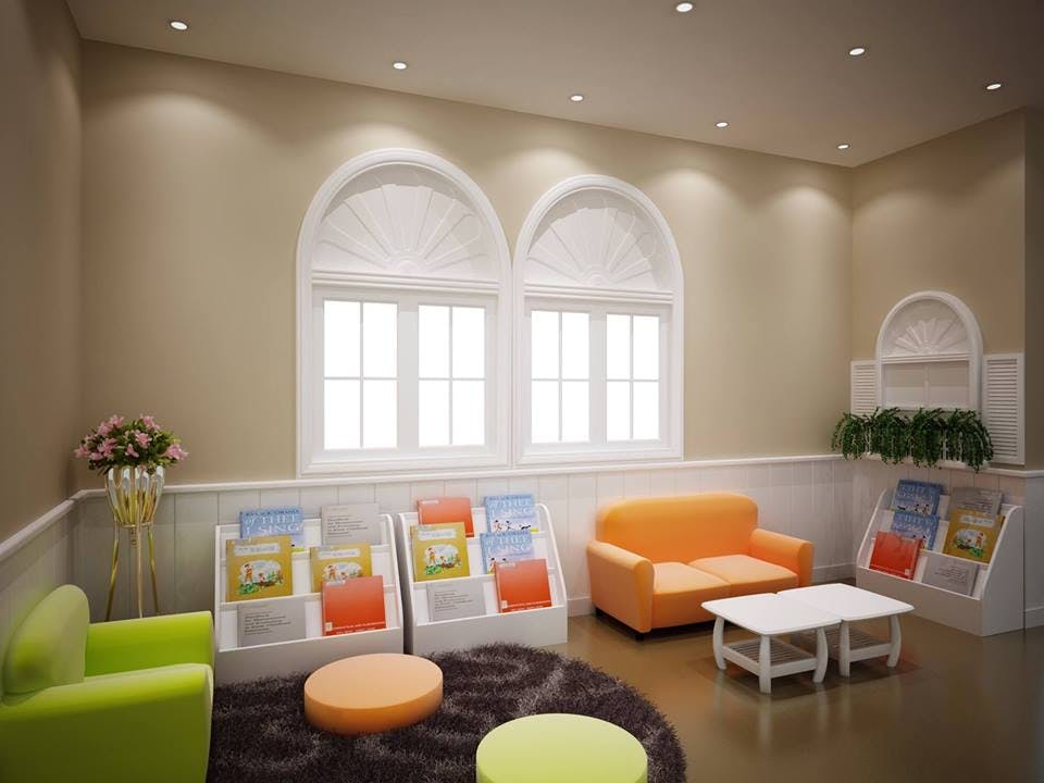 Children's reading area with small couches, tables, and book displays