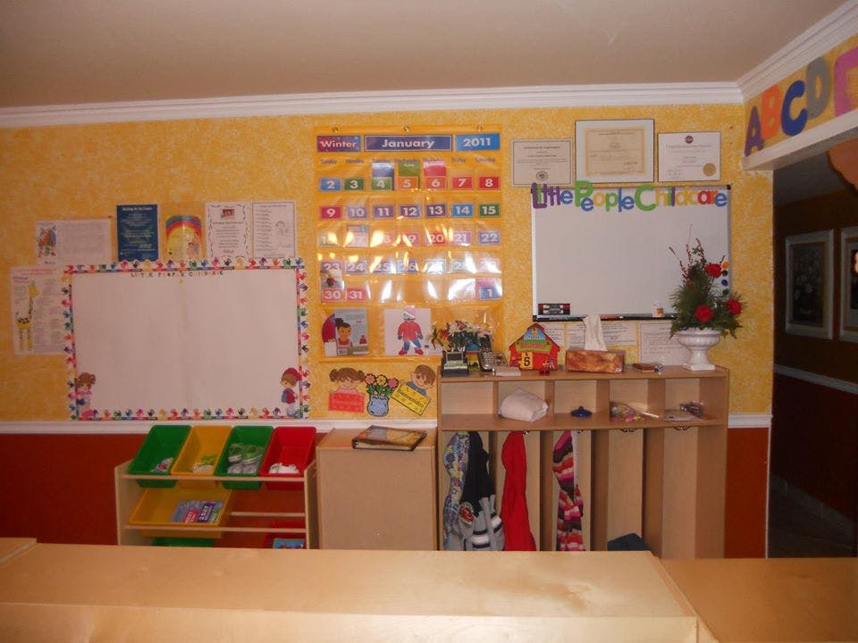 Classroom wall with a whiteboard, calendar, and storage shelves