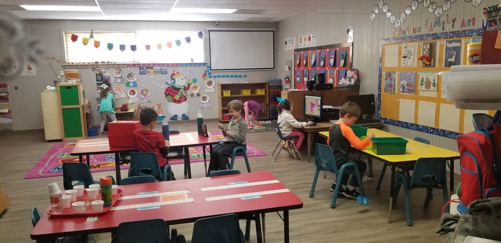 Children in a classroom at tables and computers