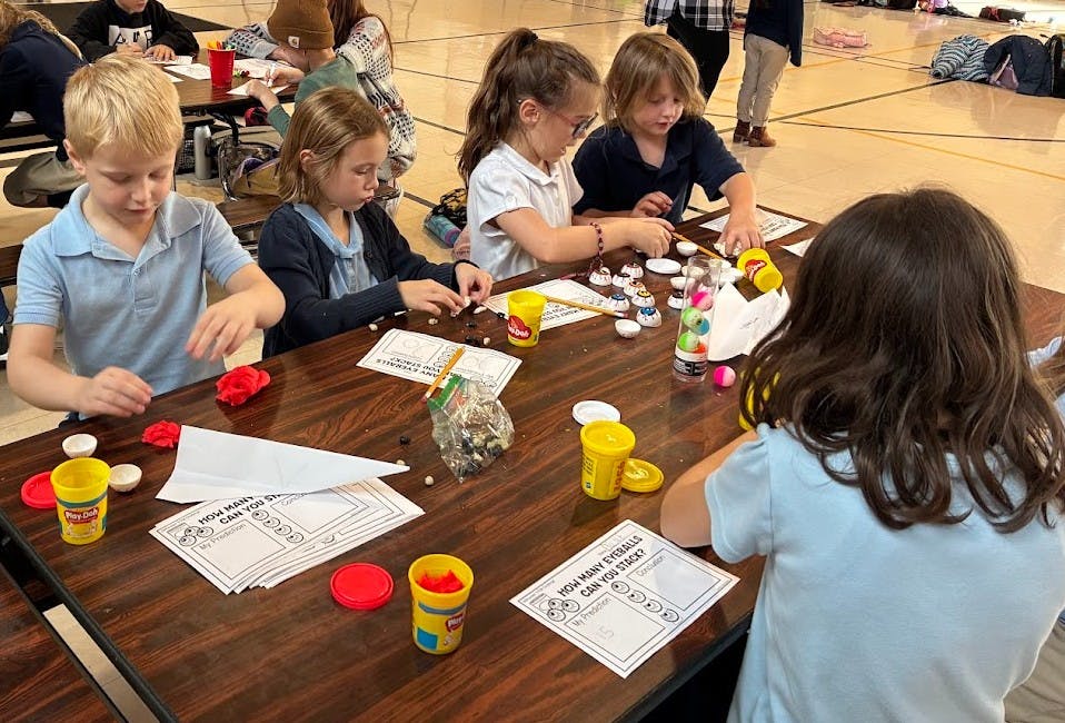 Children at tables engaging in a craft activity with play-doh