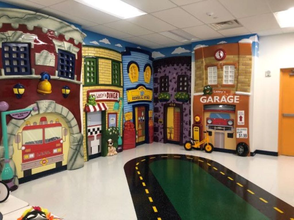 Playroom with cartoon buildings and a road on the floor