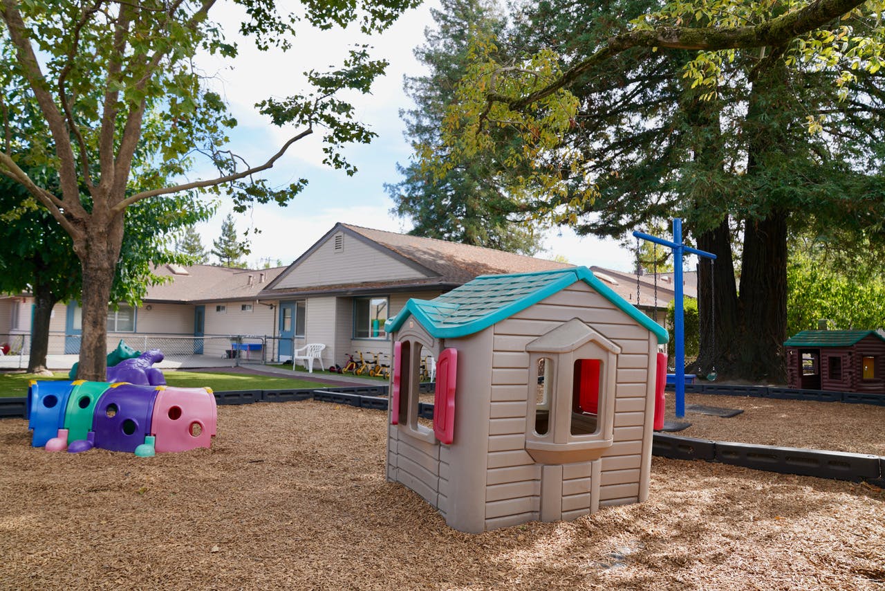 Playground with a small playhouse and colorful tunnels