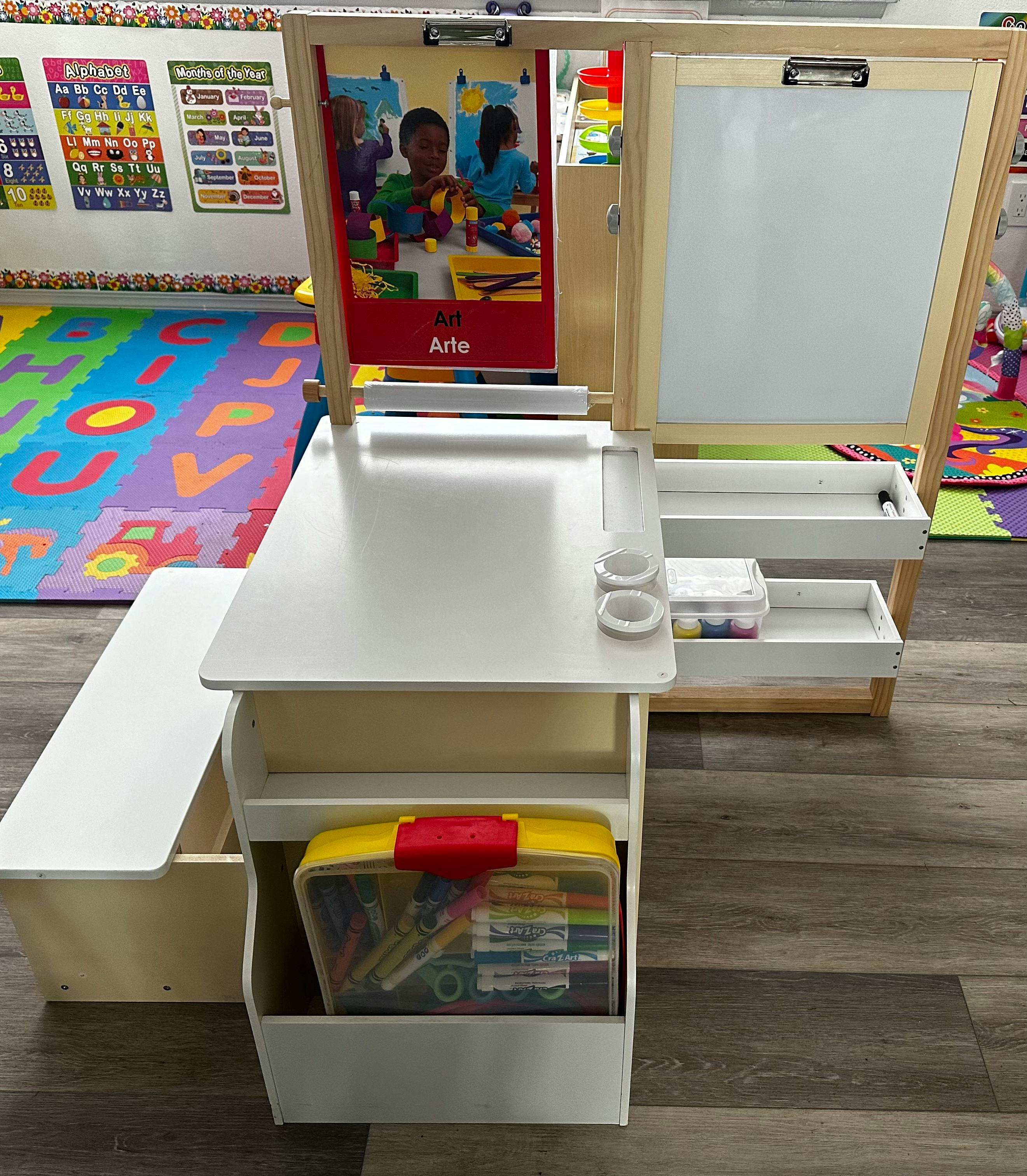 Child's art easel with a whiteboard, a bench, and art supplies