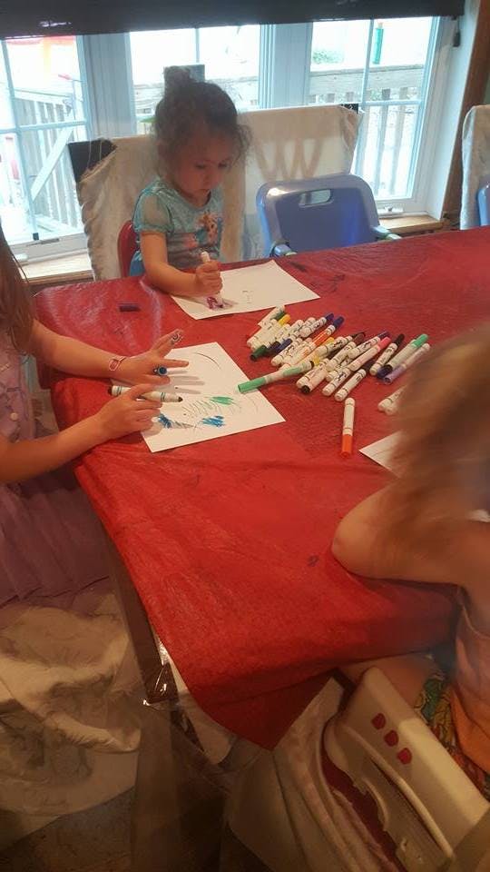 Children drawing with markers at a table