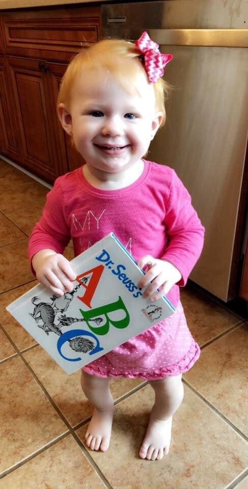 Child holding a Dr. Seuss's ABC book