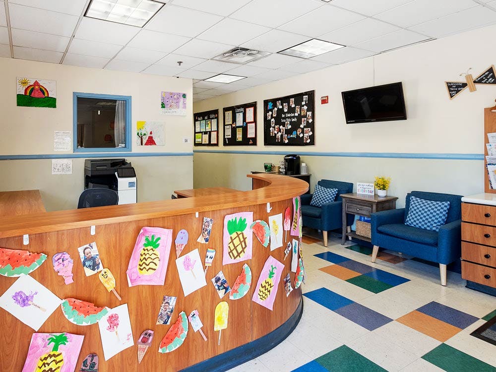 Reception desk with children's artwork and a small waiting area