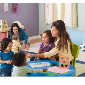 Adult and children at a table with paper and crayons