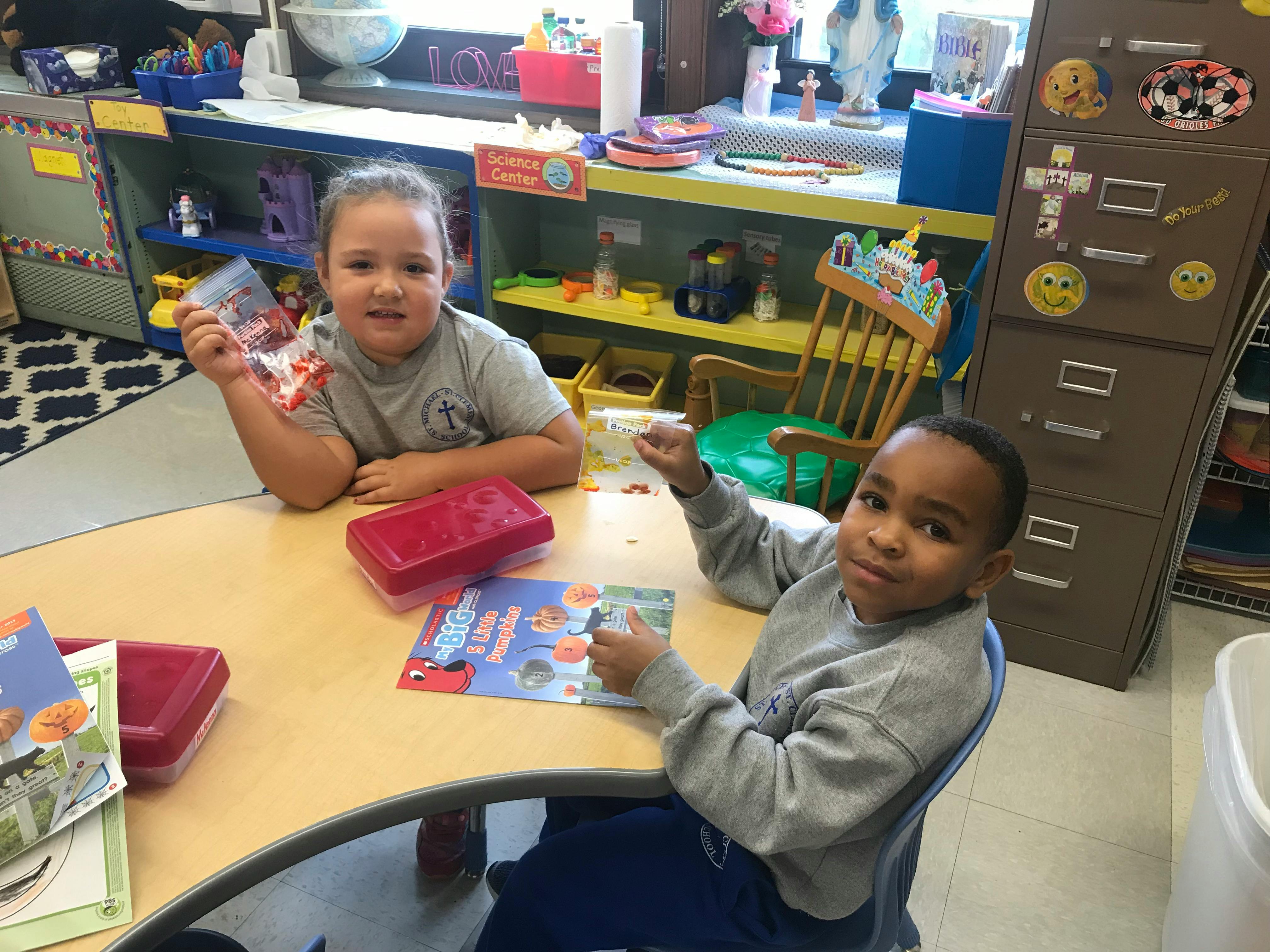 Two children sitting at a table in a classroom